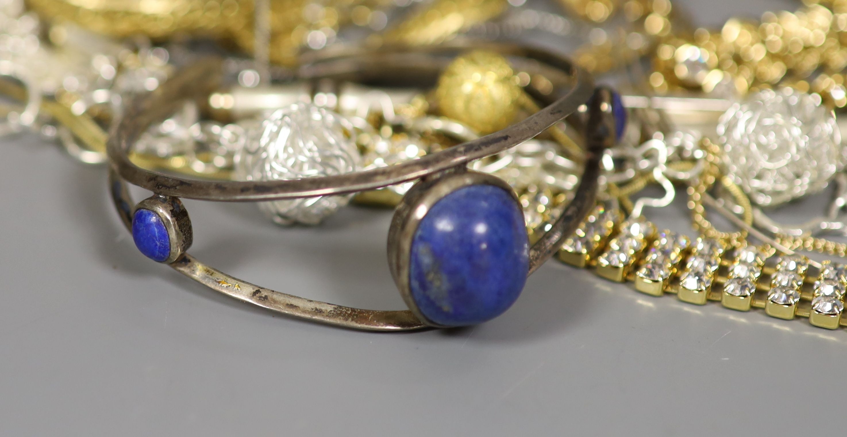 A quantity of assorted costume jewellery including a lapis lazuli set bangle.